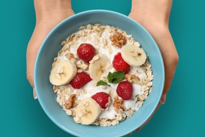 blue bowl of oatmeal with berries and bananas.